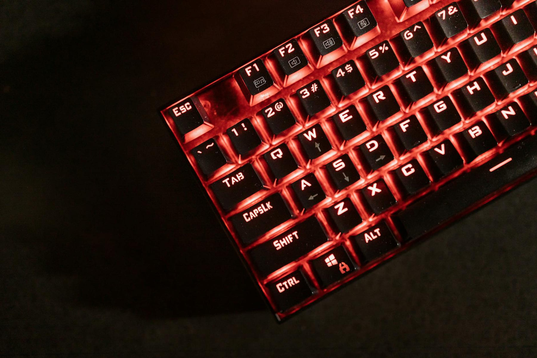 Close-up view of a red illuminated mechanical gaming keyboard in a dark room. on Frame Rate Vault