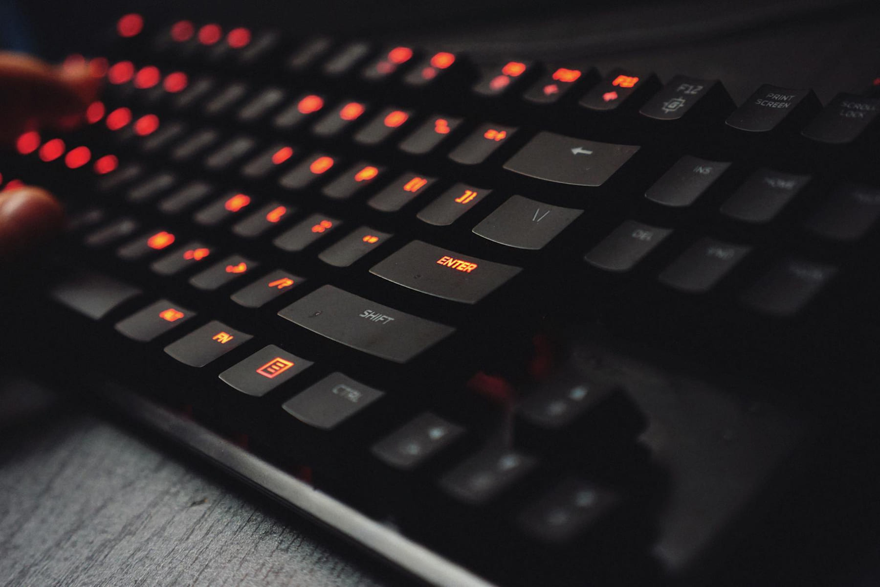 Detailed view of a gaming keyboard with backlit keys and glowing red lights. on Frame Rate Vault