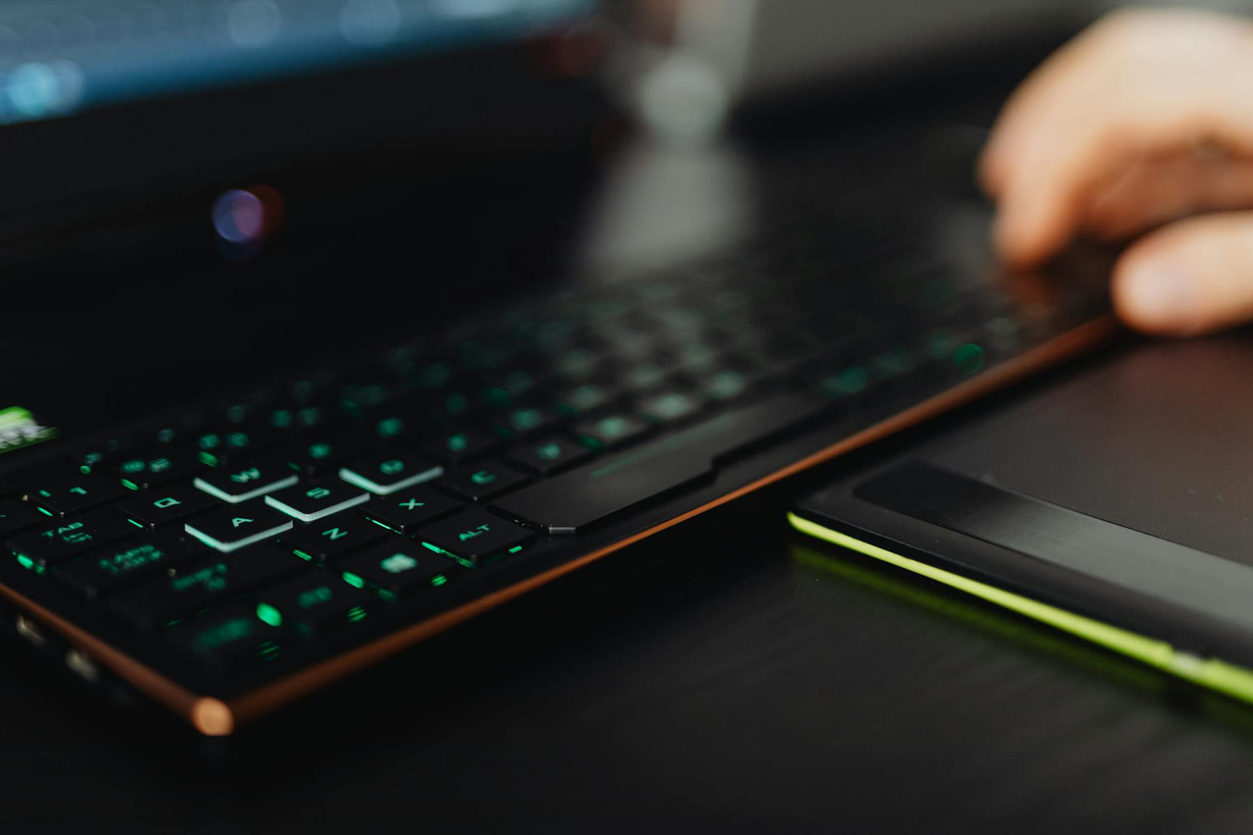 A close-up of a backlit gaming keyboard and laptop, highlighting modern technology use. on Frame Rate Vault