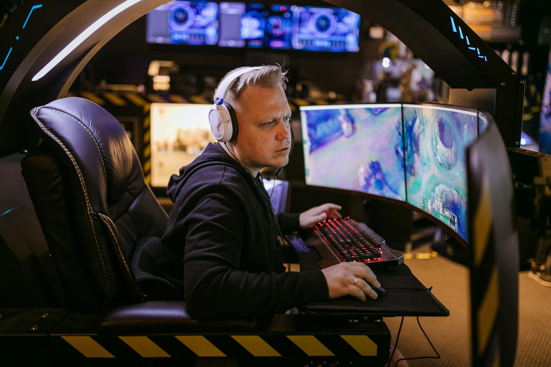 A focused gamer using an advanced multi-monitor setup in a modern gaming chair. on Frame Rate Vault