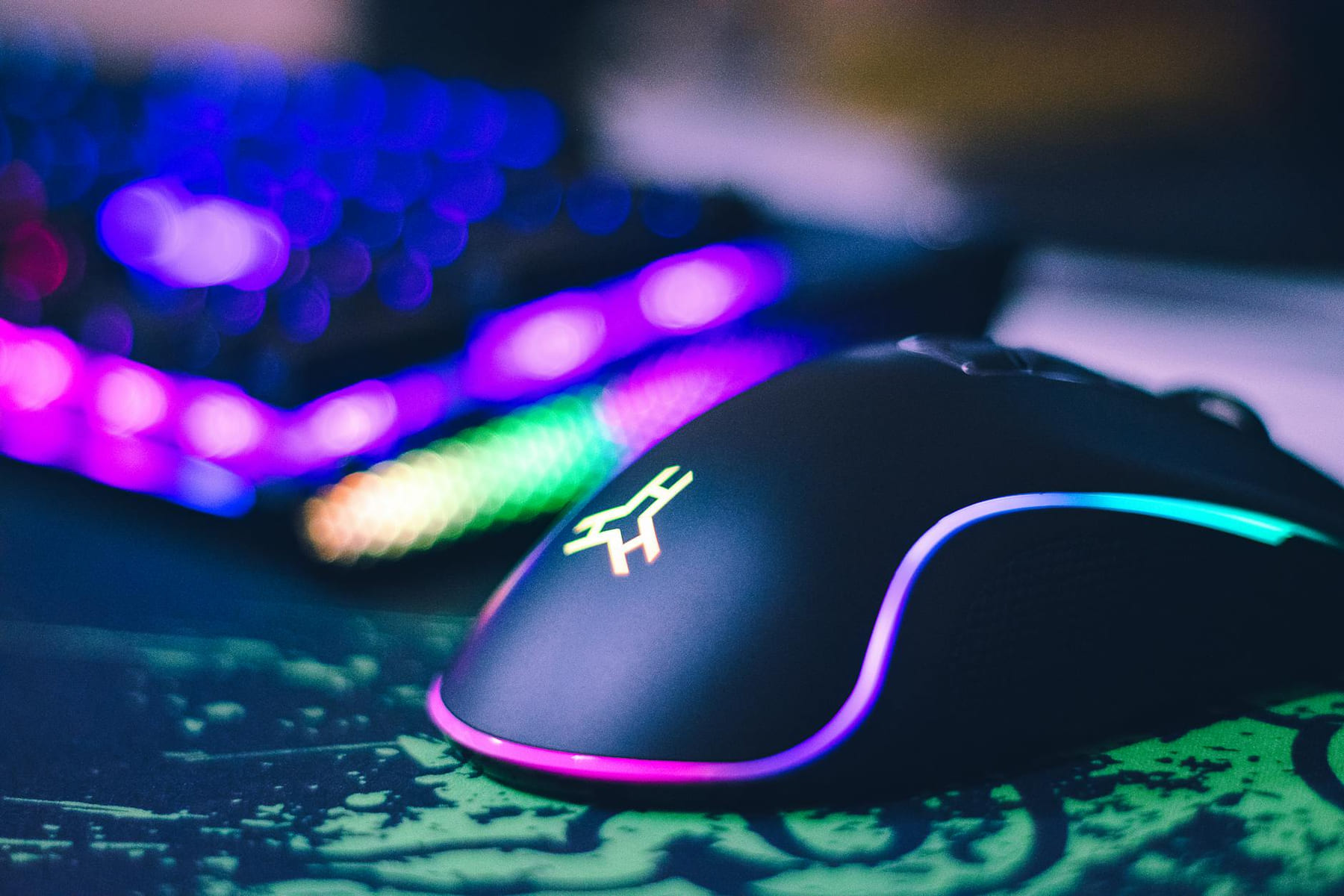 A close-up of a colorful gaming mouse and illuminated RGB keyboard, perfect for tech setups. on Frame Rate Vault
