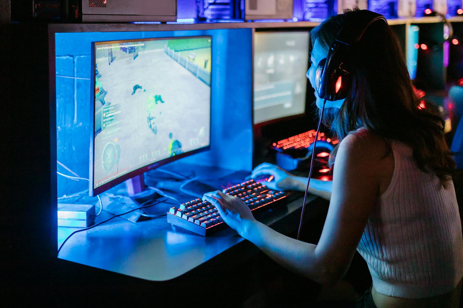 Woman enjoying a vibrant gaming session at a computer setup with a mechanical keyboard. on Frame Rate Vault